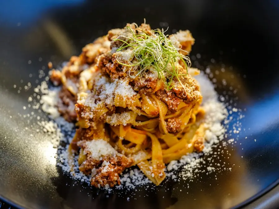 Tagliatelle al ragù con parmigiano in un piatto scuro